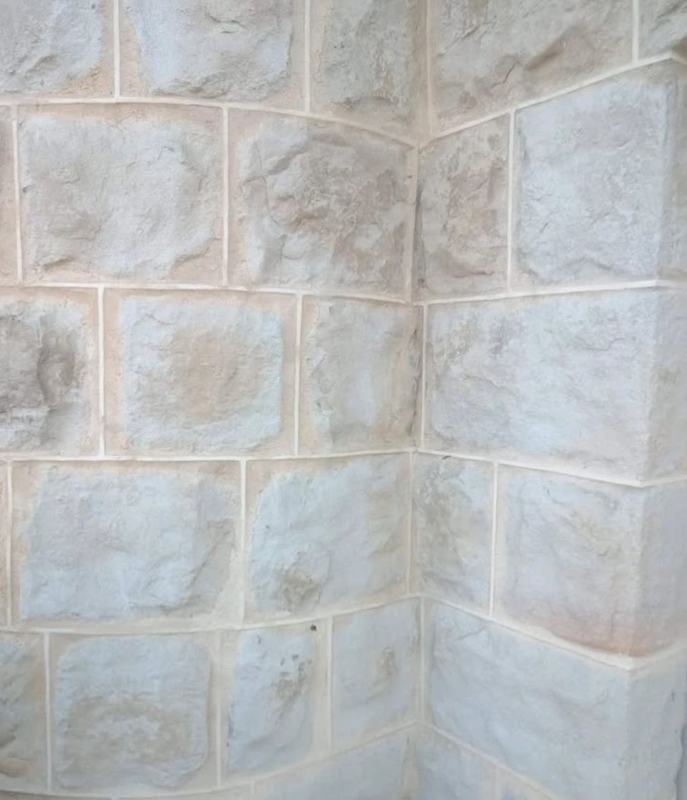 Rock-faced sandstone block wall with a curved corner