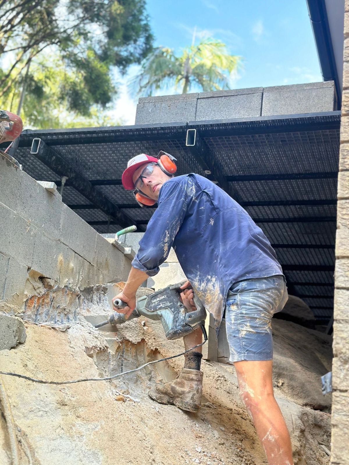 Boss Masonry stonemason cutting back a sandstone rock face on site